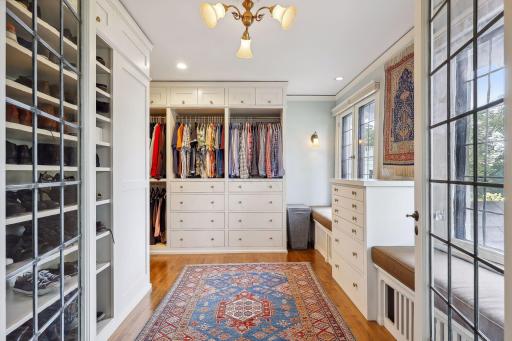 Spacious walk-in closet with built-in cabinetry, window seats, and lake views.