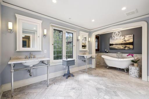 Gorgeous marble tile bath with garden views, double vanities and medicine cabinets, built-in storage cabinets, soaking tub, and large walk-in shower.