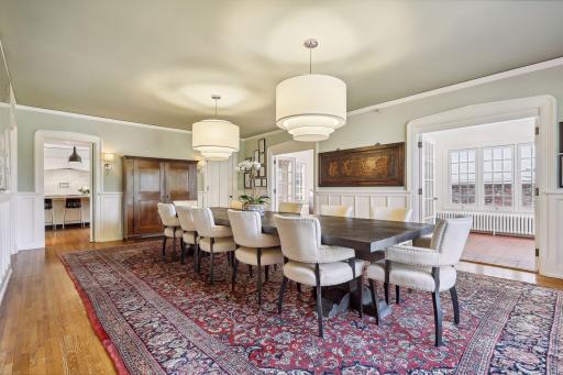 An effortlessly flowing floor plan with connectivity to the kitchen, sunroom, and front patio. A center hall leads to the formal living room and an additional sunroom.