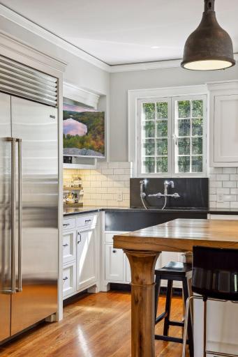 Deep apron sink, t.v. niche, and seating for up to six around the large kitchen island.