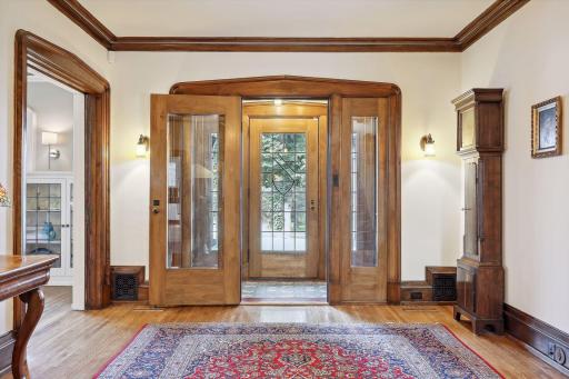 Impressive front entry hall with tiled foyer and gorgeous walnut woodwork.