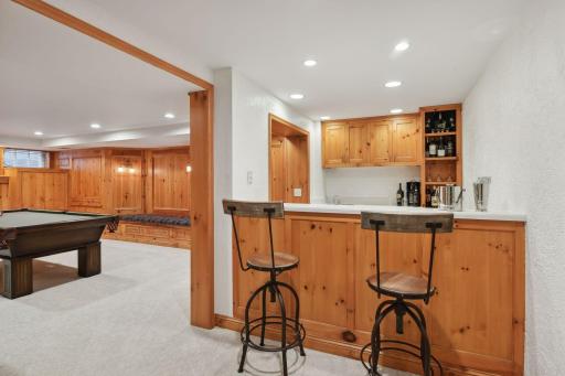 Lower level wet bar with beverage fridge and tiered bar top
