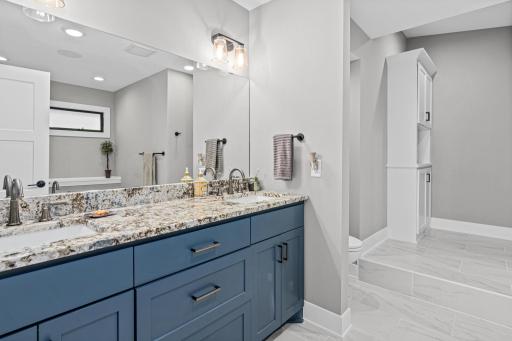 Updated primary suite has a large free-standing tub, separate shower and large walk-in closet. New custom cabinetry and solid surface countertops.