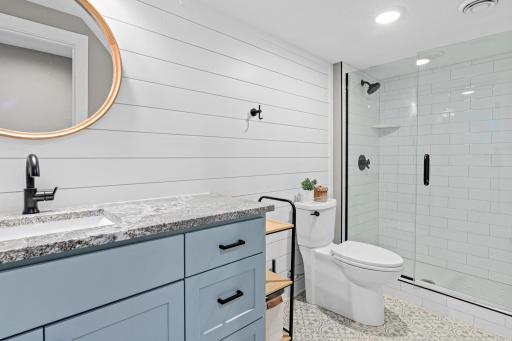 Spacious 3/4 bathroom is located downstairs near the fourth bedroom, laundry room and access to the lake- perfect for guests, or after spending the day on the water.