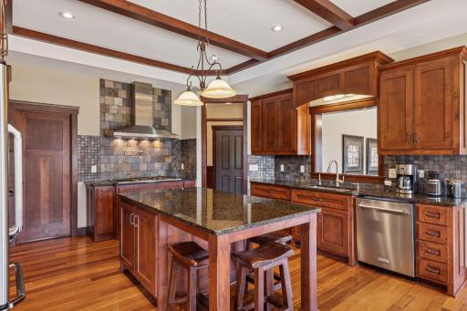 The gourmet kitchen is complete with gas cooktop and vent hood, pot filler, double wall ovens, a walk-in pantry, large island with seating and convenient access to the mudroom and garage for bringing in the groceries!