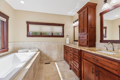 The primary bedroom suite bathroom offers heated floors, dual sinks, a soaking tub, walk-in shower and private water closet.