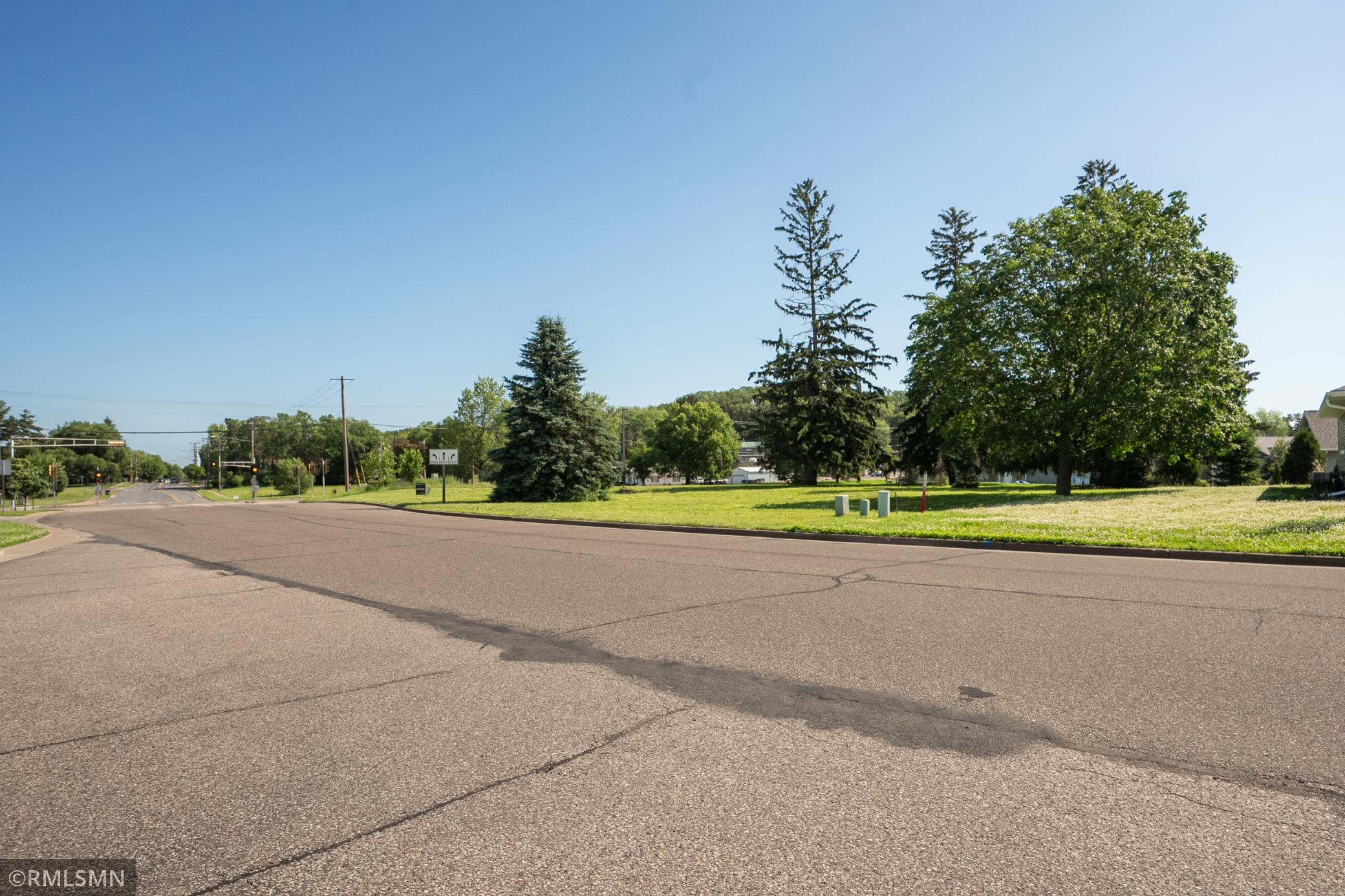 Side street view with clear look at neighborhood roads and green space.