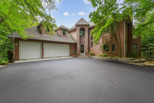 The elegant brick façade adds timeless charm to the grand two-story entrance of the home, while the recently seal-coated driveway enhances both curb appeal and functionality.