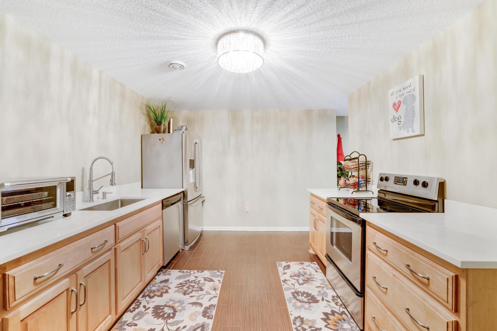 Lower level full kitchen with stainless steal appliances and quartz tops! Whether you're hosting a summer BBQ or enjoying a quiet evening by the fire, this area is sure to become the secondary heart of your home.