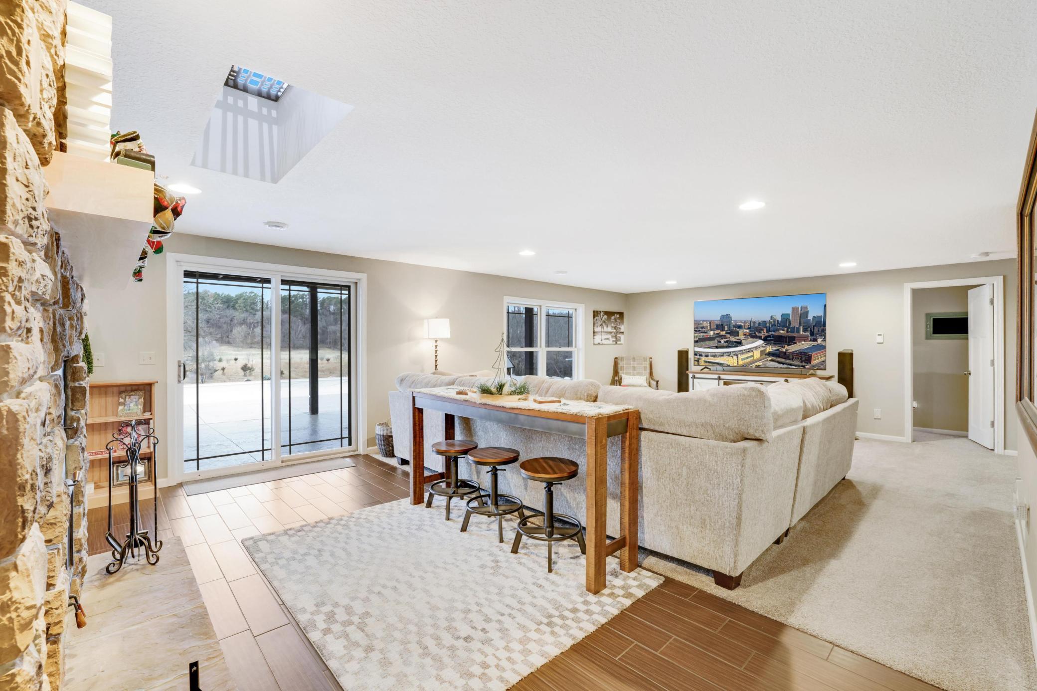 Step into the inviting lower level living room, where cozy wood-burning fireplace sets the perfect ambiance. With a full secondary kitchen at your fingertips, this space seamlessly connects to the pool area, making it an ideal spot for entertaining!