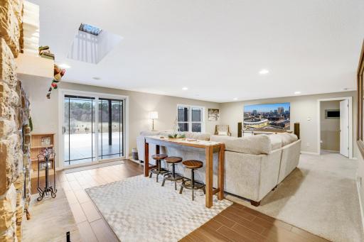 Step into the inviting lower level living room, where cozy wood-burning fireplace sets the perfect ambiance. With a full secondary kitchen at your fingertips, this space seamlessly connects to the pool area, making it an ideal spot for entertaining!