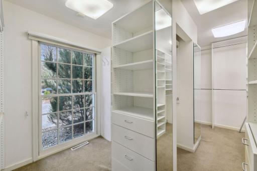 Large walk-in closet with organizational components to keep clothing and accessories in place