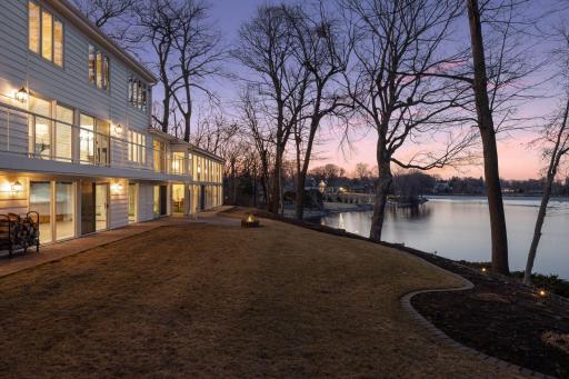 Twilight view of the backyard and tranquil lakeshore