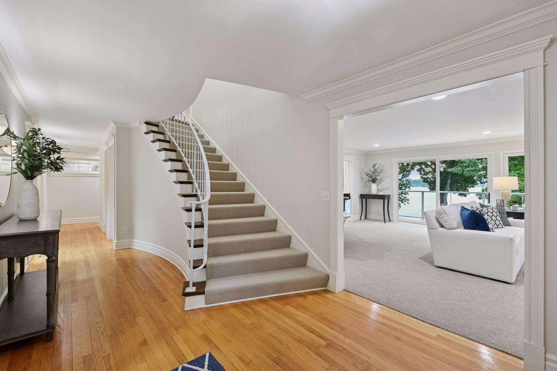 Gleaming hardwood floors and newly carpeted stairs lead to the upper level