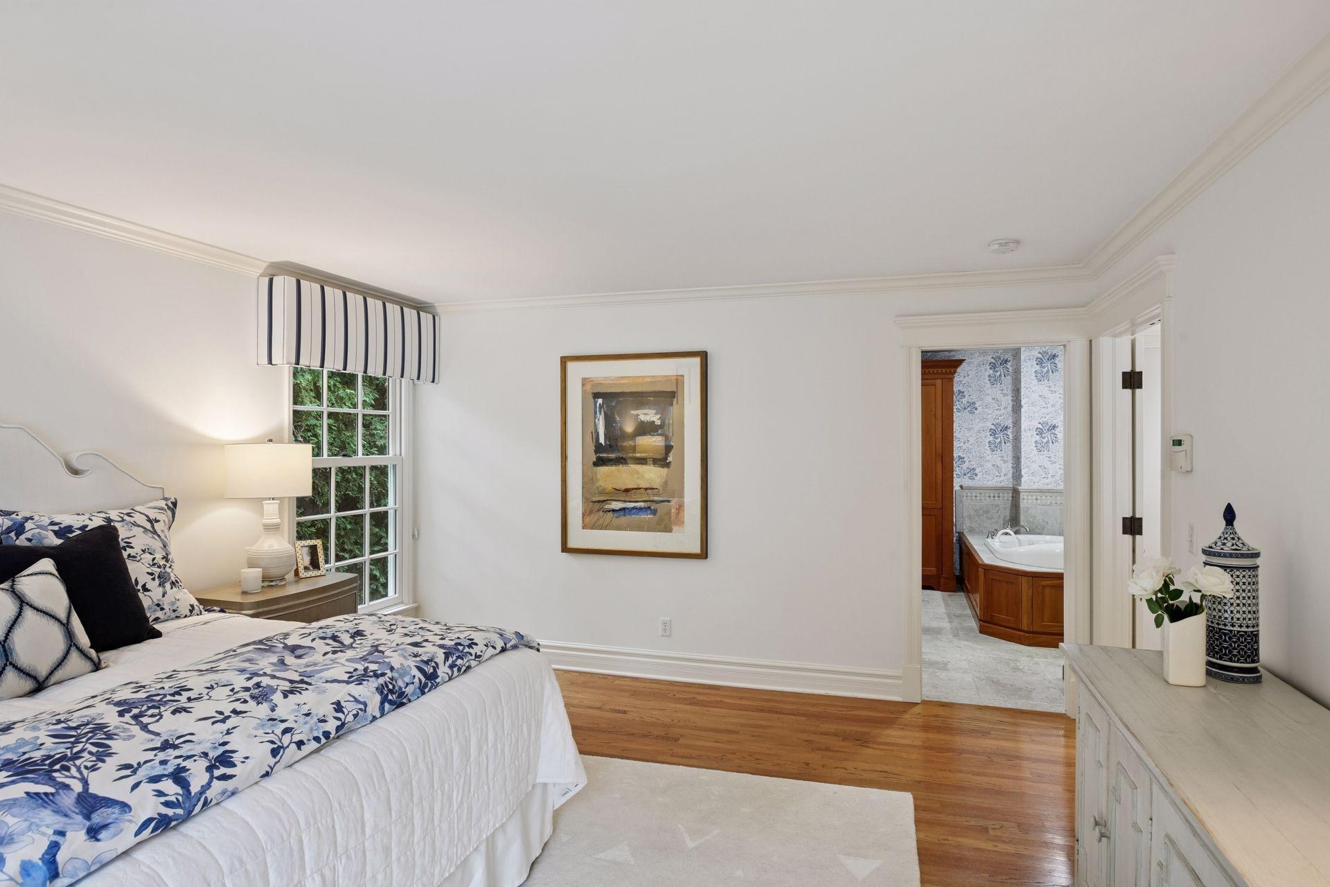 Highlights of the freshly painted primary bedroom include hardwood floors, natural light, lake views, and access to the balcony