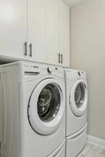 Front-load washer/dryer are conveniently located just off the closet; laundry room also features cabinets and supply closet for more storage space