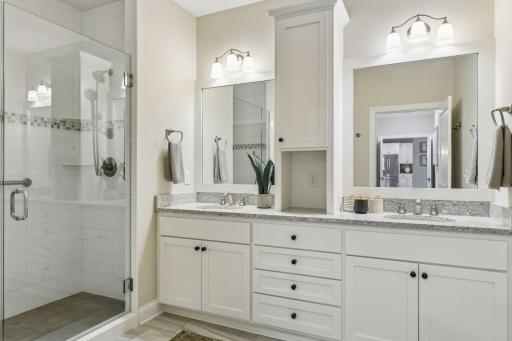 Large primary bathroom features dual vanity areas, storage space, and walk-in shower
