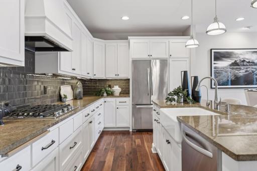 Additional kitchen highlights include granite tops, tiled backsplash, and plenty of cabinet/pantry space for storage