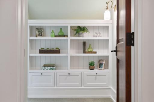 As you enter the first Junior Bedroom you are greeted by a wall of built-in shelving and drawers.
