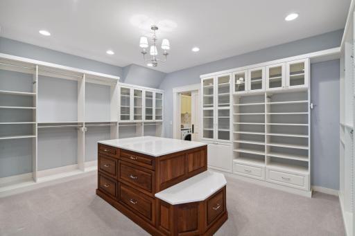 The ultimate Primary Closet! This space features a built-in dresser with Cambria countertop and finished with a custom organizer system from Twin City Closet Company.