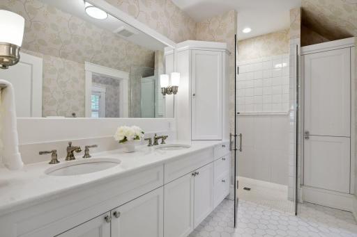 The private en suite bathroom enjoys a double vanity with Cambria countertops, a heated tile floor, curbless shower with reinforced walls for a future handrailing and a private water closet.