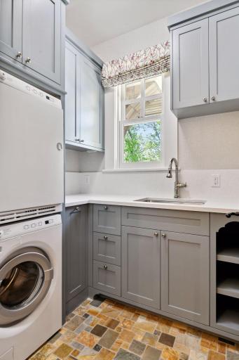 The Main Level Laundry Room features Cambria countertops, Asko stacking washer and dryer and laundry sink.