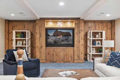 The wood paneled feature wall offers a built-in entertainment center with cabinetry for your AV components.