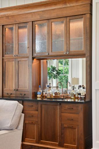 The walk-up wet bar features Cambria countertops, a hammered copper sink, and Sub-Zero refrigerator drawers.