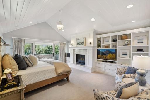 The serene Primary Bedroom offers a cozy gas fireplace, an entire wall of built-in bookshelves, and a private deck —your personal haven of comfort and retreat.