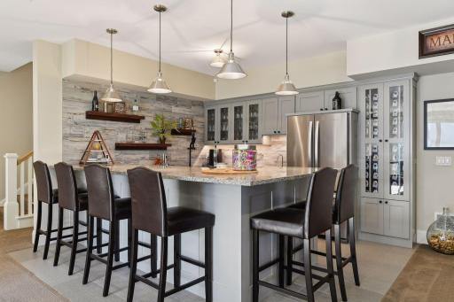 Effortlessly entertain guests on the lower level, featuring a kitchen equipped with a fridge and microwave.