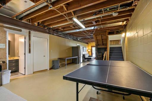Stairs from main level to lower-level recreation space. Three-quarter bath in left of photo.