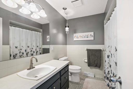 Upper level full bath with tile backsplash and floors.