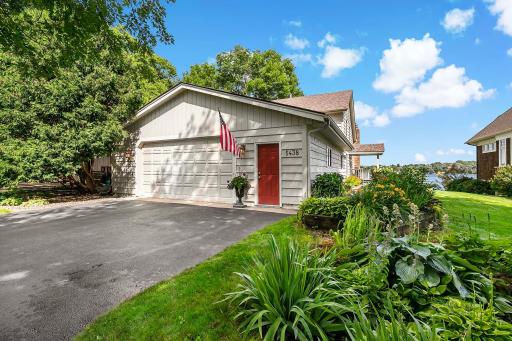 Asphalt driveway and garage entry. Attractive perennials line the walkway to front entry.