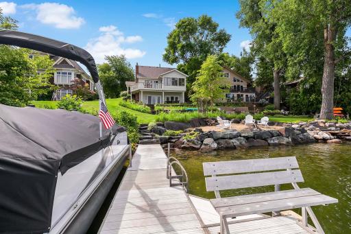 A look from the lake at the property's exquisite exterior setting with a gently sloping yard to the dock and riprap shore composed of trap rock boulders from Dresser, Wis.