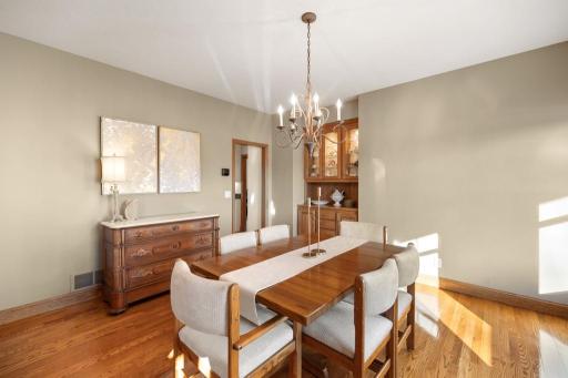 Rich hardwood floors create a grounded, inviting atmosphere, while the built-in buffet offers both style and function, ideal for storing your favorite pieces or serving guests with ease.