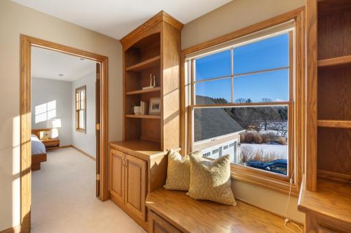 This charming nook, tucked away in the upstairs hallway, offers the perfect spot to unwind. With built-in shelves and cupboards framing a cozy window seat, it invites you to slow down and relax.