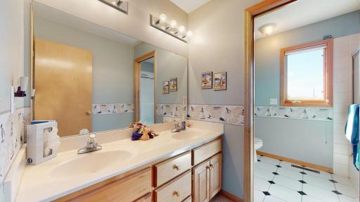 Full bathroom upstairs has dual sinks and separate room for shower and stool.