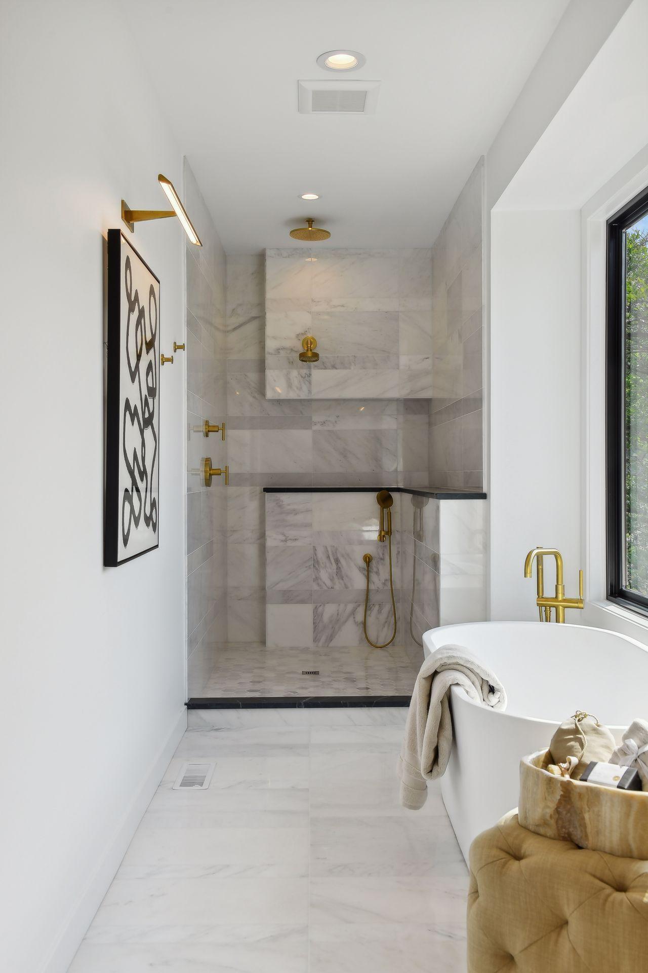 A custom marble surround with gorgeous fixtury selections and a full glass shower wall will impress