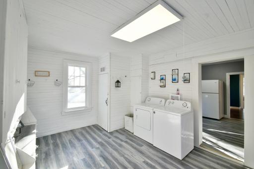 This spacious and bright laundry room offers both functionality and charm, featuring sleek new flooring and a crisp, clean design. Ample natural light pours through the window, making the space inviting and enjoyable. With plenty of room.