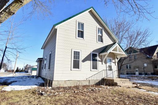 Exterior of a beautifully updated 3-bedroom, 1-bath home in Evansville. The property features a freshly installed steel roof (2024), vinyl siding, and a welcoming front entry with a small covered porch. Nestled on a spacious corner lot.
