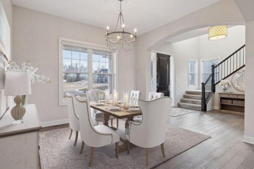 Property has been virtually staged as a formal dining room. The front door opens to reveal an open-concept layout with main floor office or dining room.