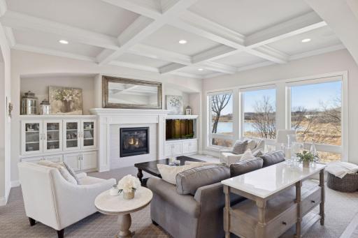 The living room features floor-to-ceiling windows, coffered ceiling, and gas fireplace flanked by custom built-in cabinets.
