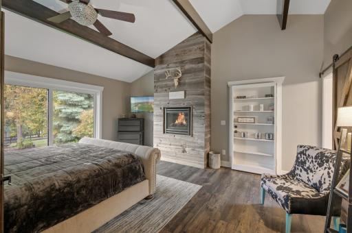 Main Level Primary with gas burning fireplace and sliding doors to add a deck to. Book shelf is hidden door to secret entrance of guest house