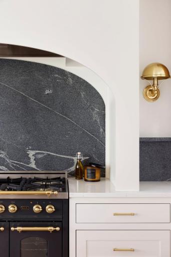 An example of the detail accenting a chef's cooking station with a soap stone back splash wall and accent lighting as a detail