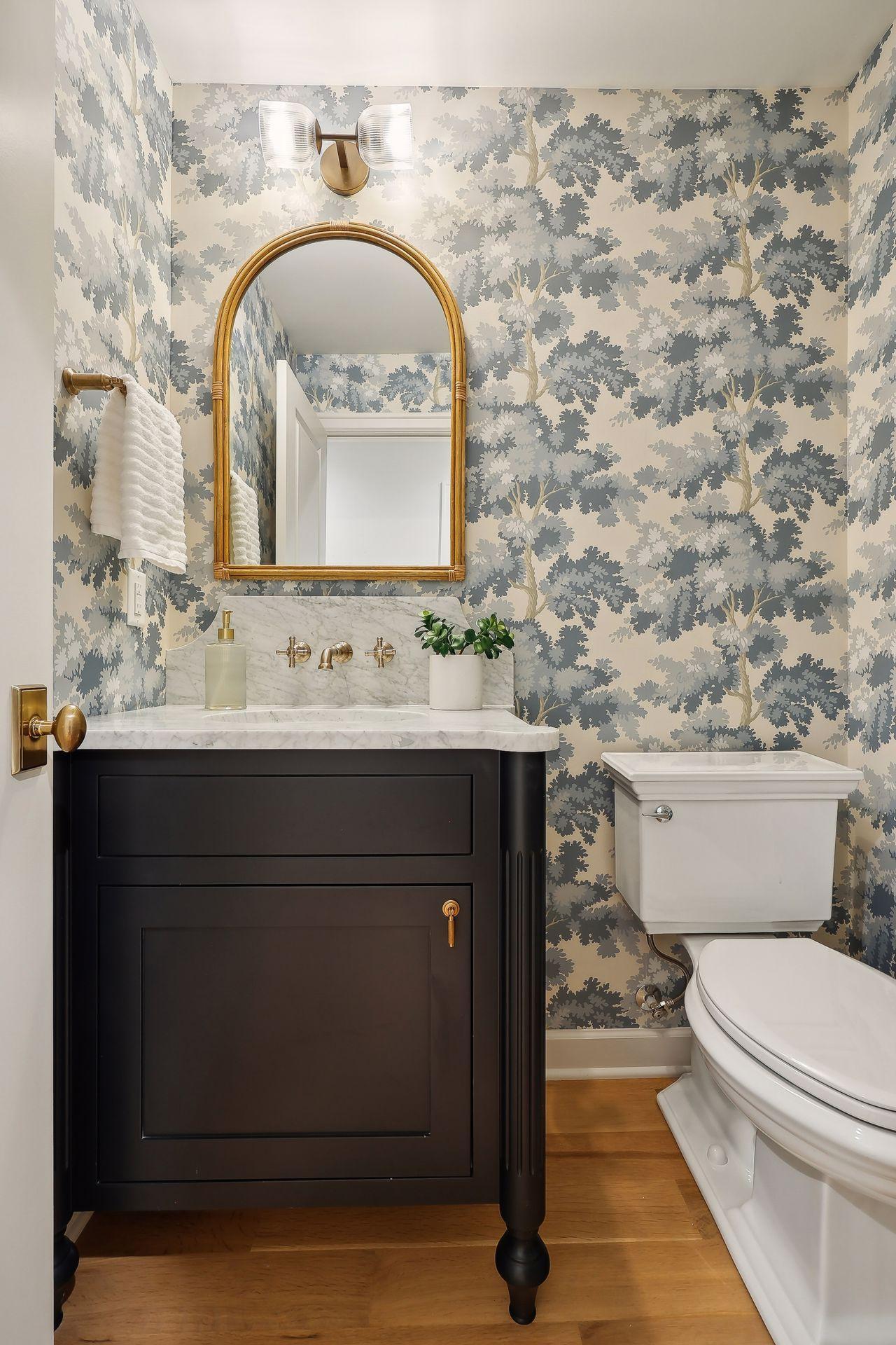 This perfect powder room bath on the main level features chic wallpaper that adds a touch of elegance and personality.