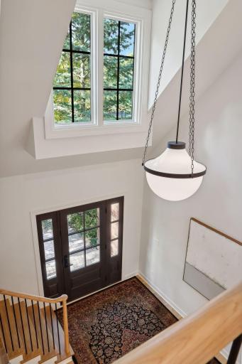 Enjoy a stunning view from the top of the stairs, overlooking the spacious foyer below. This inviting entryway sets the tone with its open design, creating a warm welcome for guests and a touch of elegance to the home.