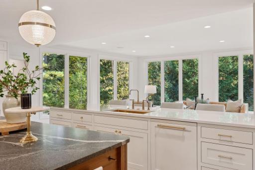 This inviting open kitchen features a stylish bar that overlooks a lush backyard, creating a seamless connection to nature. Perfect for entertaining, this space allows you to enjoy beautiful outdoor views while cooking and gathering with loved ones.