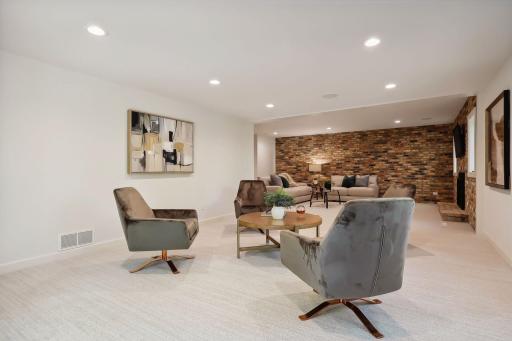 This lower level family room features an open, flowing floor plan that enhances the spaciousness and invites natural light throughout.