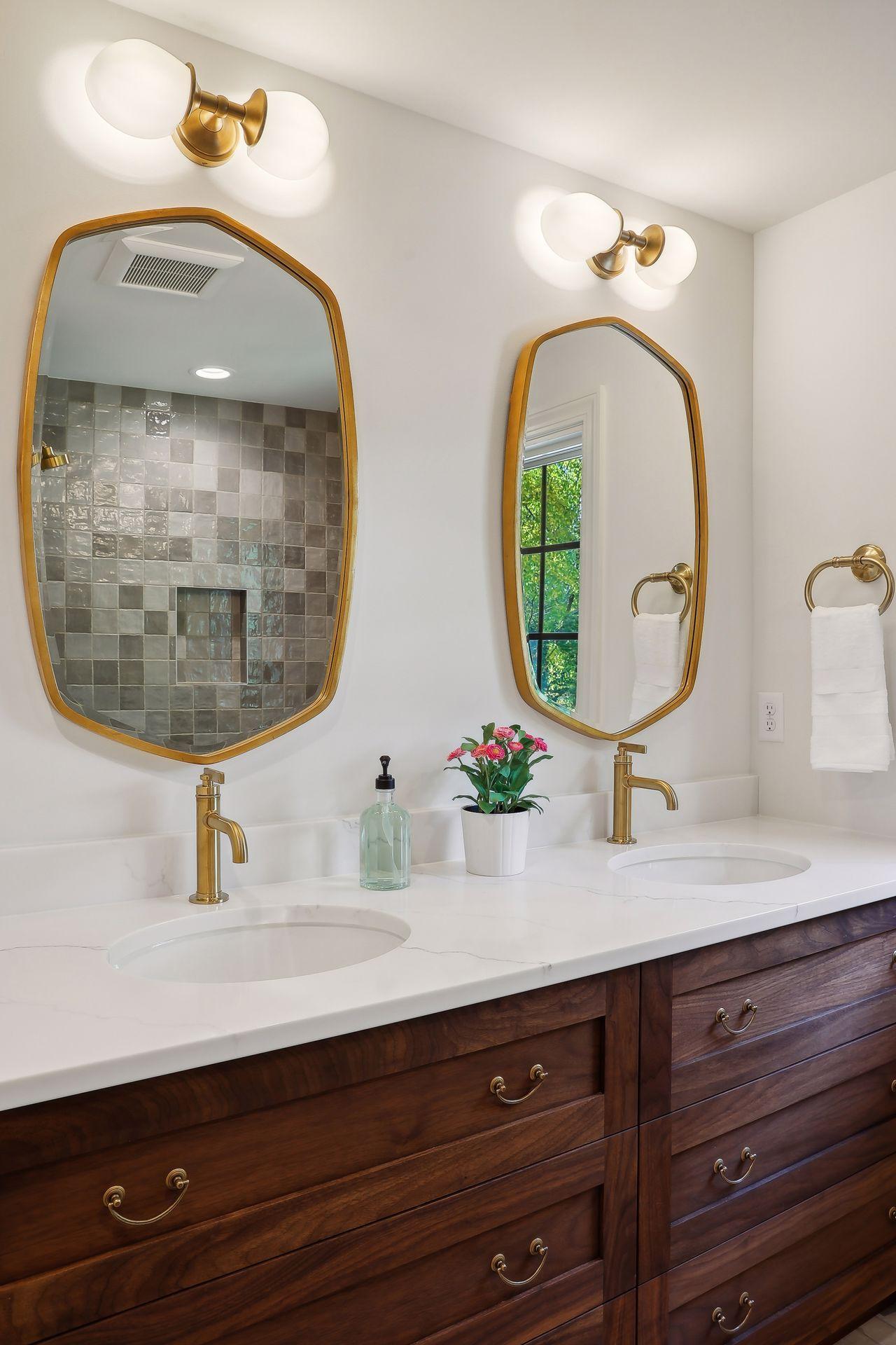 This stunning bathroom features all the modern conveniences, including elegant gold tone fixtures and ample drawer storage.