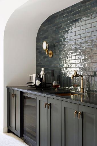 This inviting lower level features stunning original brick accent walls paired with a modern beverage bar. The perfect blend of rustic charm and contemporary style creates a cozy yet stylish space for entertaining or unwinding.